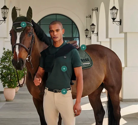 A rider in a BOSS Equestrian polo beside his horse, with hotspot markers